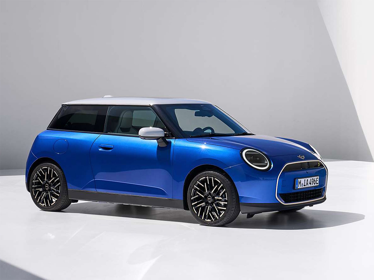 A blue Mini Cooper with black accents and a white roof.