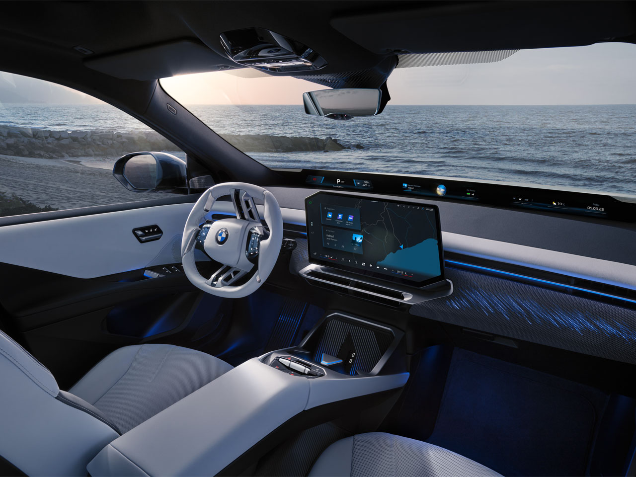 Interior of the BMW iX3 50 featuring a modern dashboard, large central screen, BMW logo on the steering wheel, and light-colored seats.