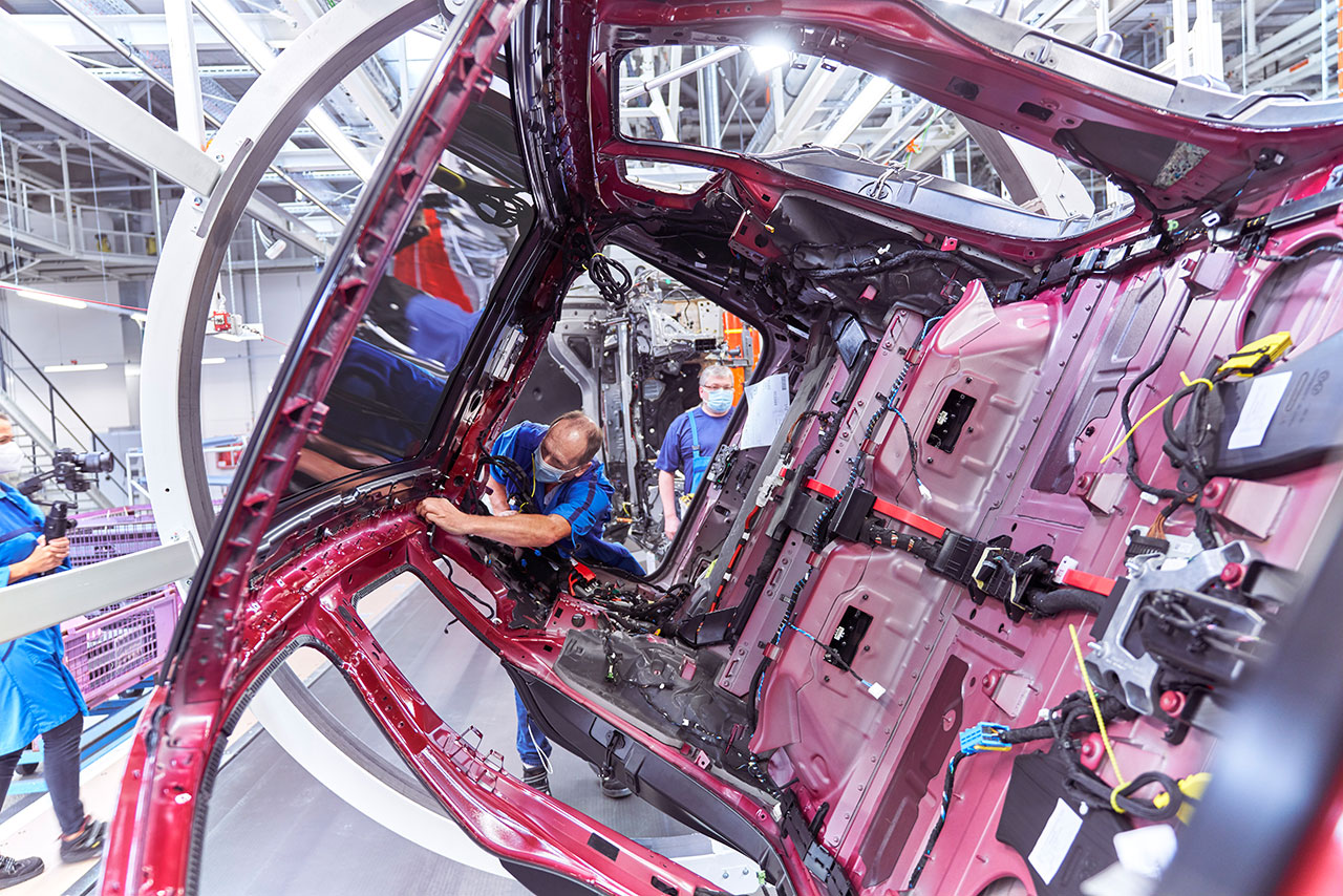 Employees are working on the inside of a car body