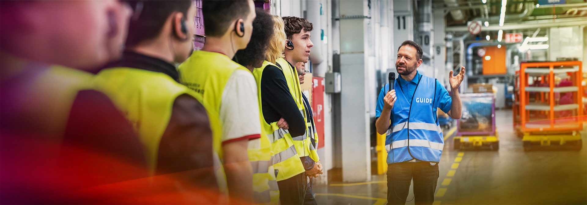 A Tourguide is touring visitors through the production halls.