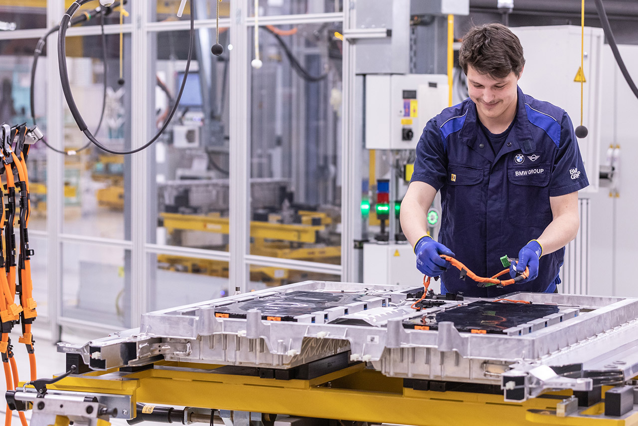 A employee in batterie production is assembling a battery.