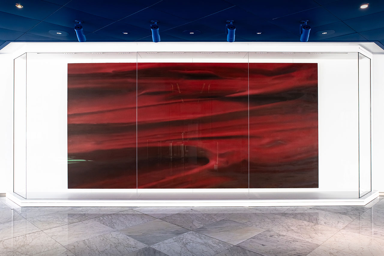A red painting hanging on a wall