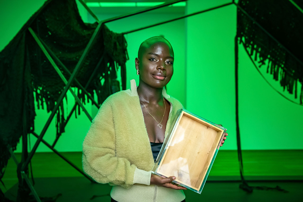 A woman holding a piece of wood in a green room