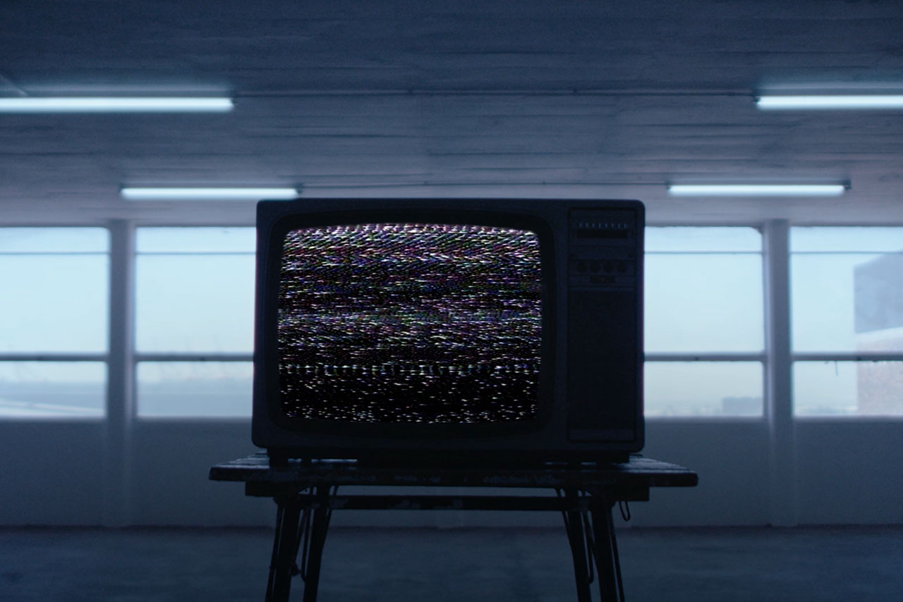 television with a static picture on a stool in an empty room