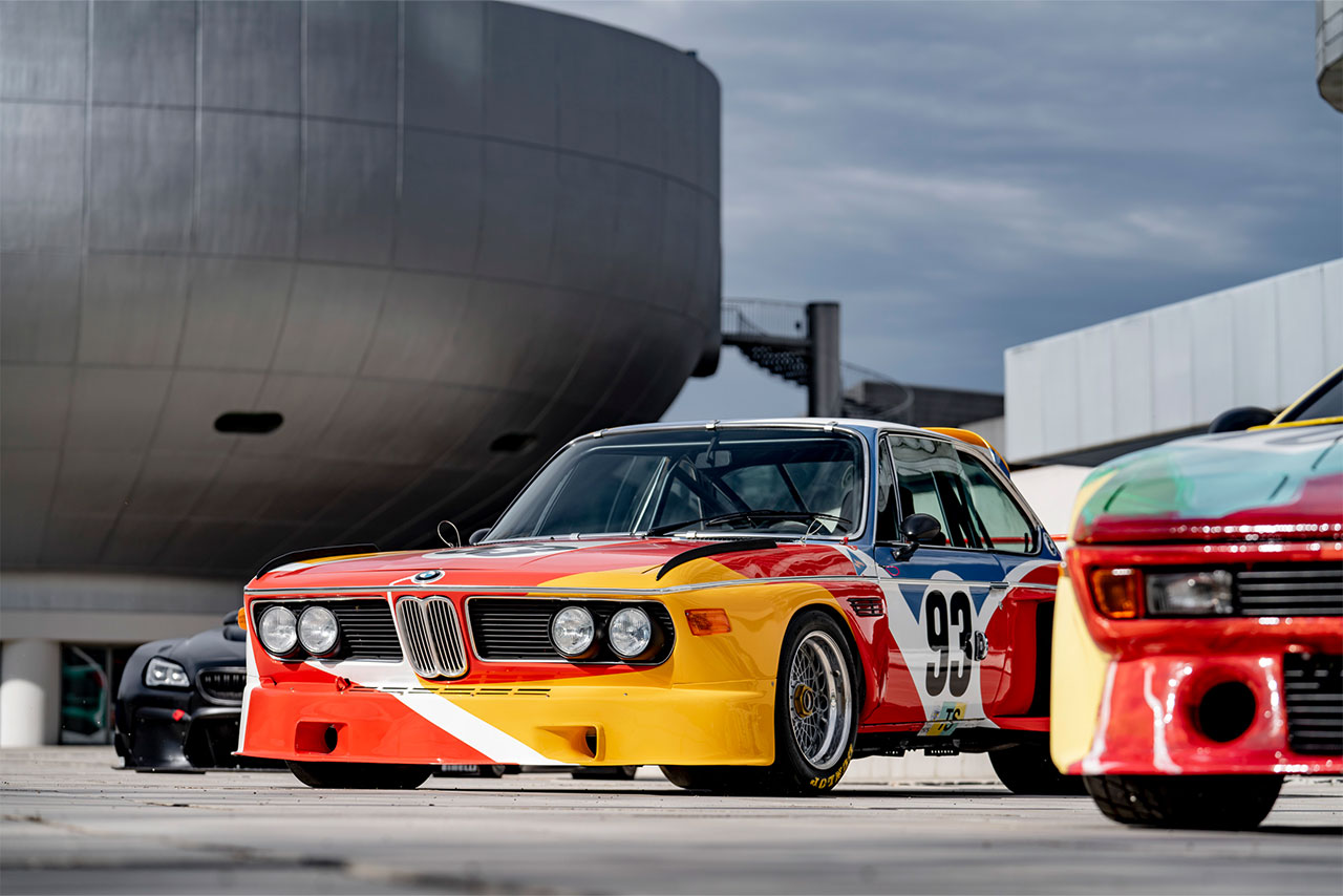 Two historical BMW vehicles parked infront of the BMW Museum.