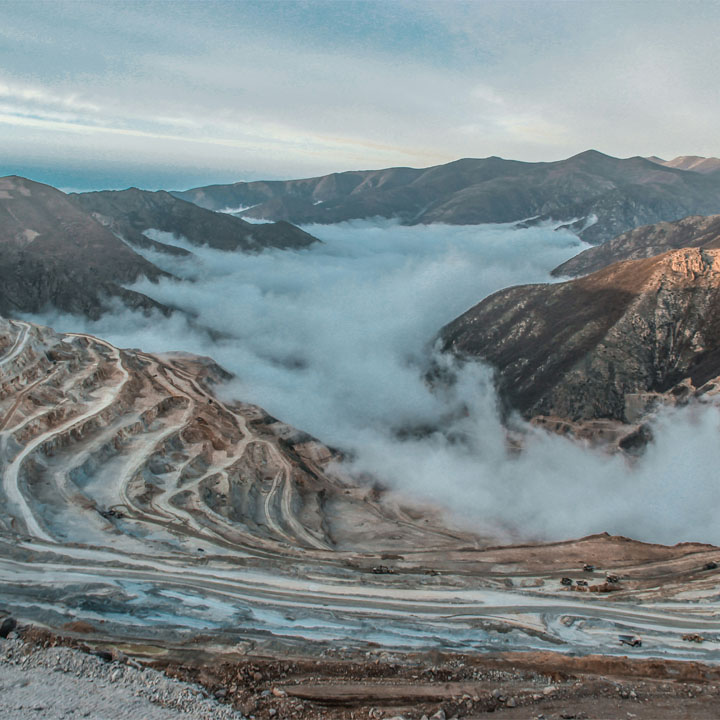 A snow-covered mountain range surrounded by dense clouds, forming a majestic landscape.