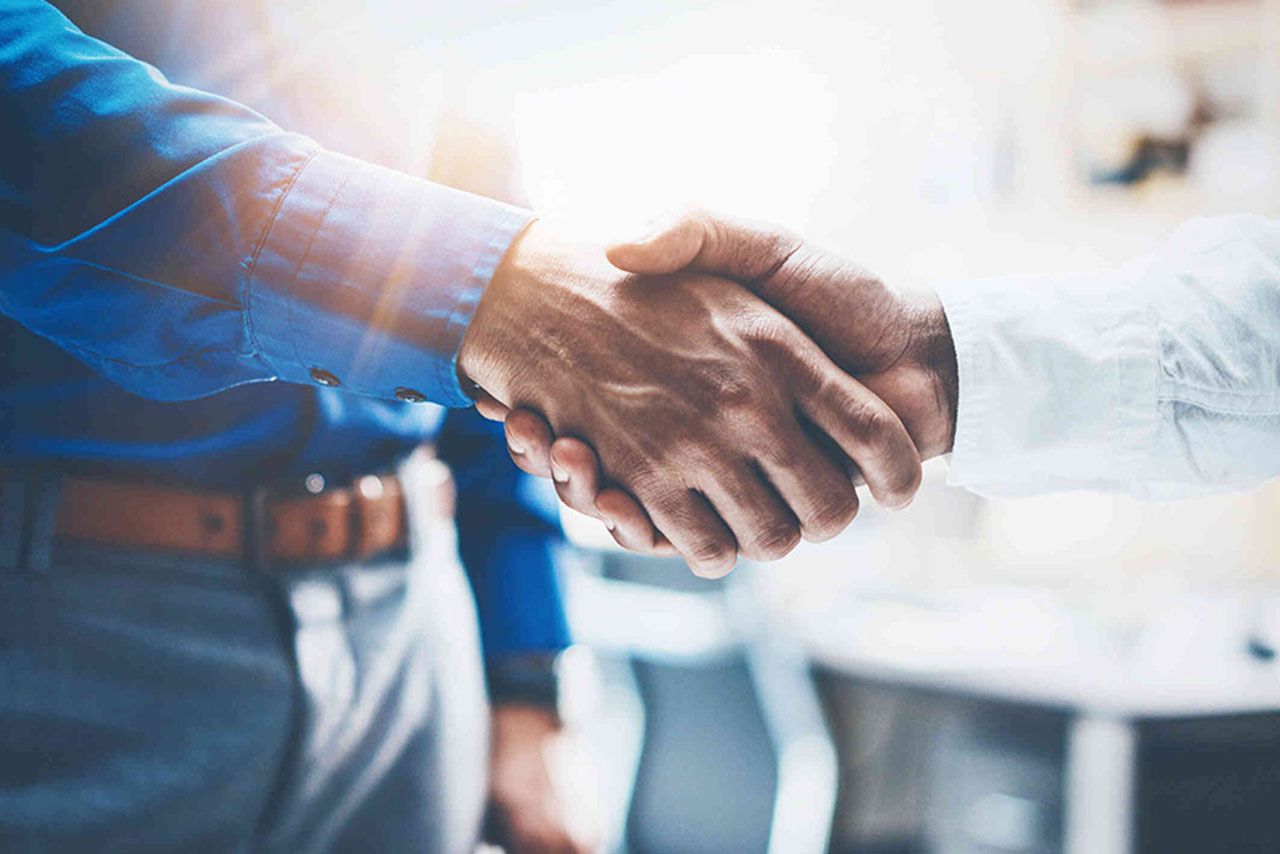 Two people in an office shake hands.