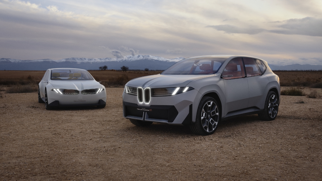 Zwei BMW Visionfahrzeuge stehen nebeneinander, im Hintergrund sind hohe Berge.