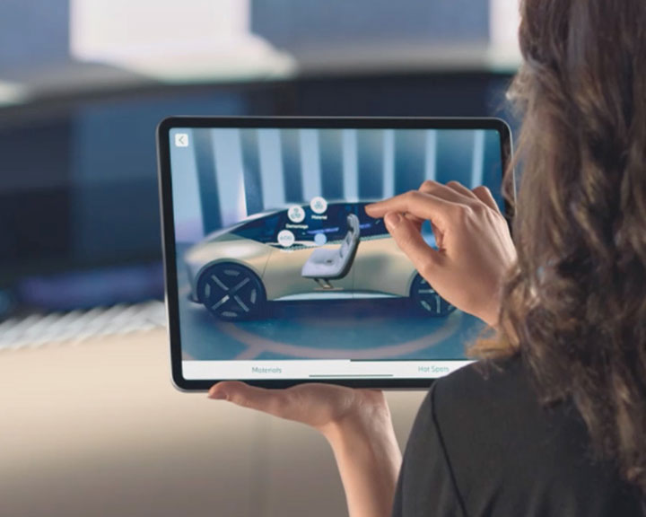 Frau schaut sich die Funktionen ihres BMW Fahrzeugs auf einem Tablet an.