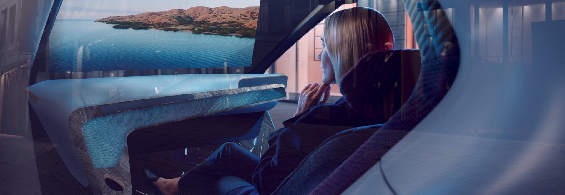 Person sitzt in einem futuristischen Fahrzeuginnenraum mit Panoramasicht auf Wasserlandschaft, keine Bedienelemente sichtbar.