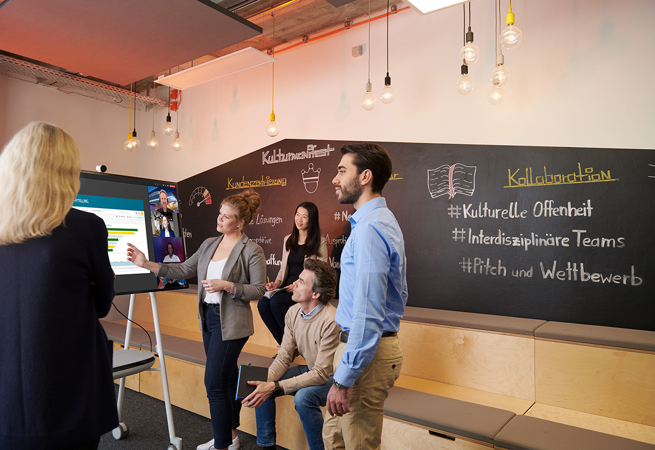 BMW Mitarbeiter unterhalten sich während einer Besprechung in einem Präsentationsraum.