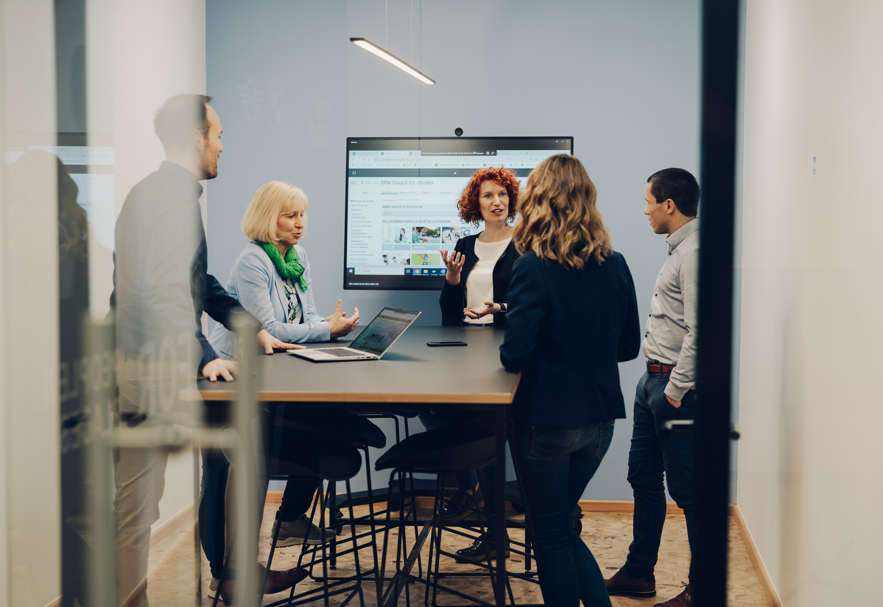 BMW Mitarbeiter unterhalten sich in einem Besprechungsraum.