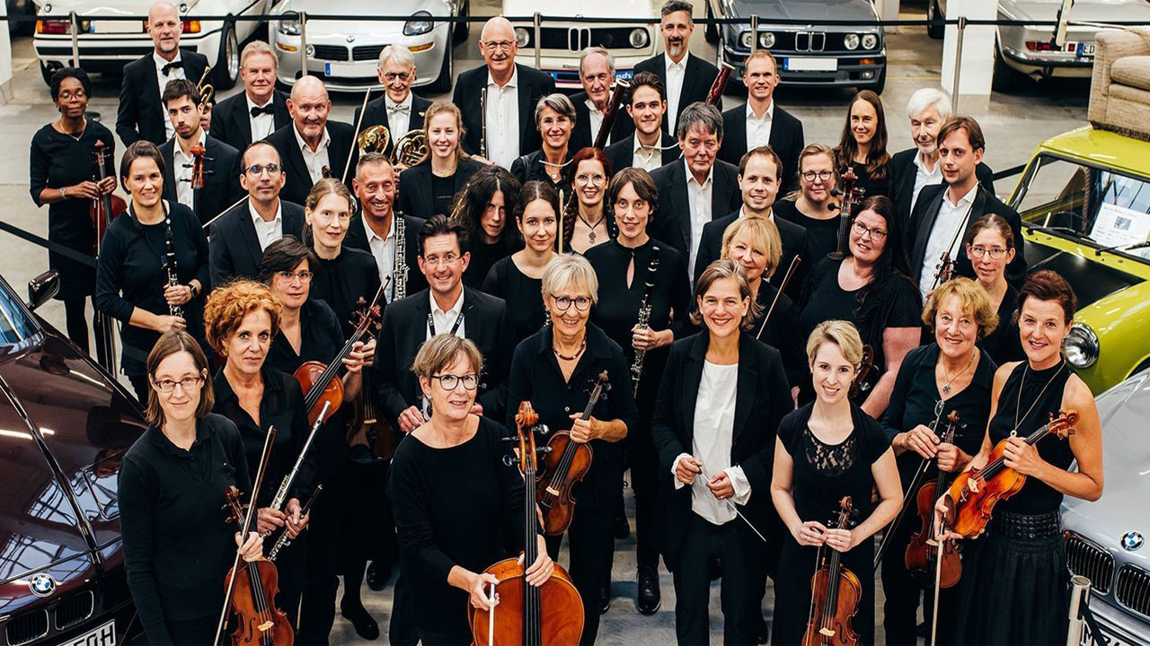 Mehrere Personen stehen zusammen und halten ihre Instrumente für ein Gruppenfoto.