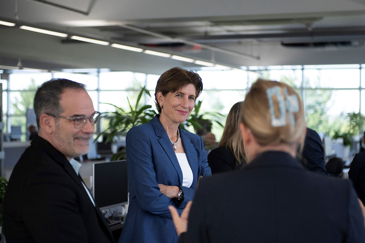 Mitglied des Vorstands der BMW AG Ilka Horstmeier im Anzug spricht mit anderen Personen in einem geschäftlichen Umfeld.