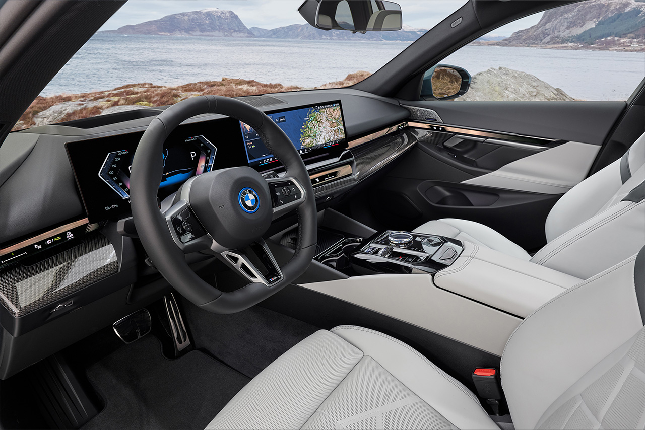 Das Interieur eines BMW i5 Touring mit eingeschaltetem BMW Curved Display.