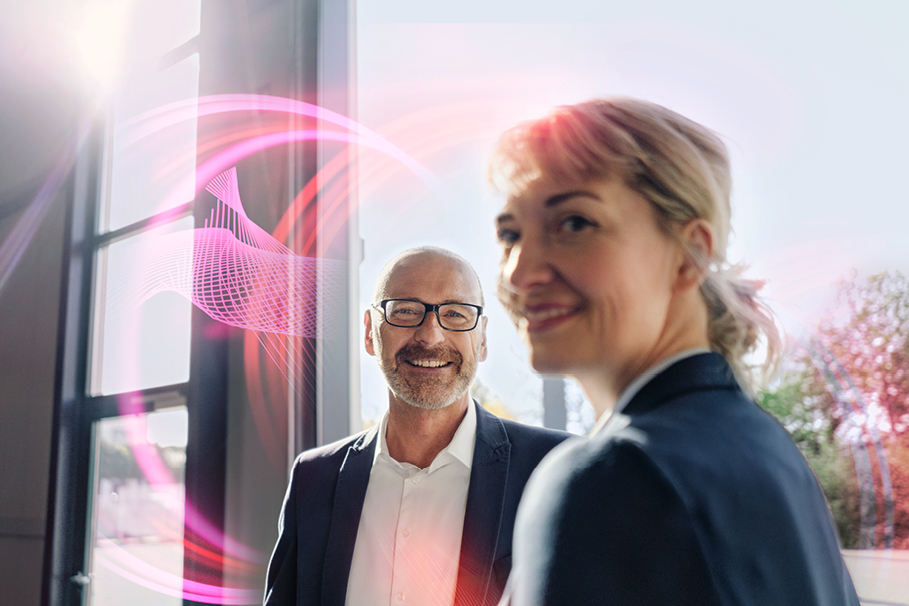 Ein Mann und eine Frau stehen nebeneinander. Um sie herum sind pinke Lichtformen