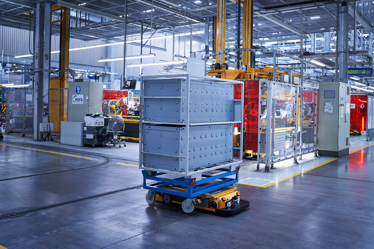 Autonome Logistikroboter transportieren große Kisten durch die Fabrik