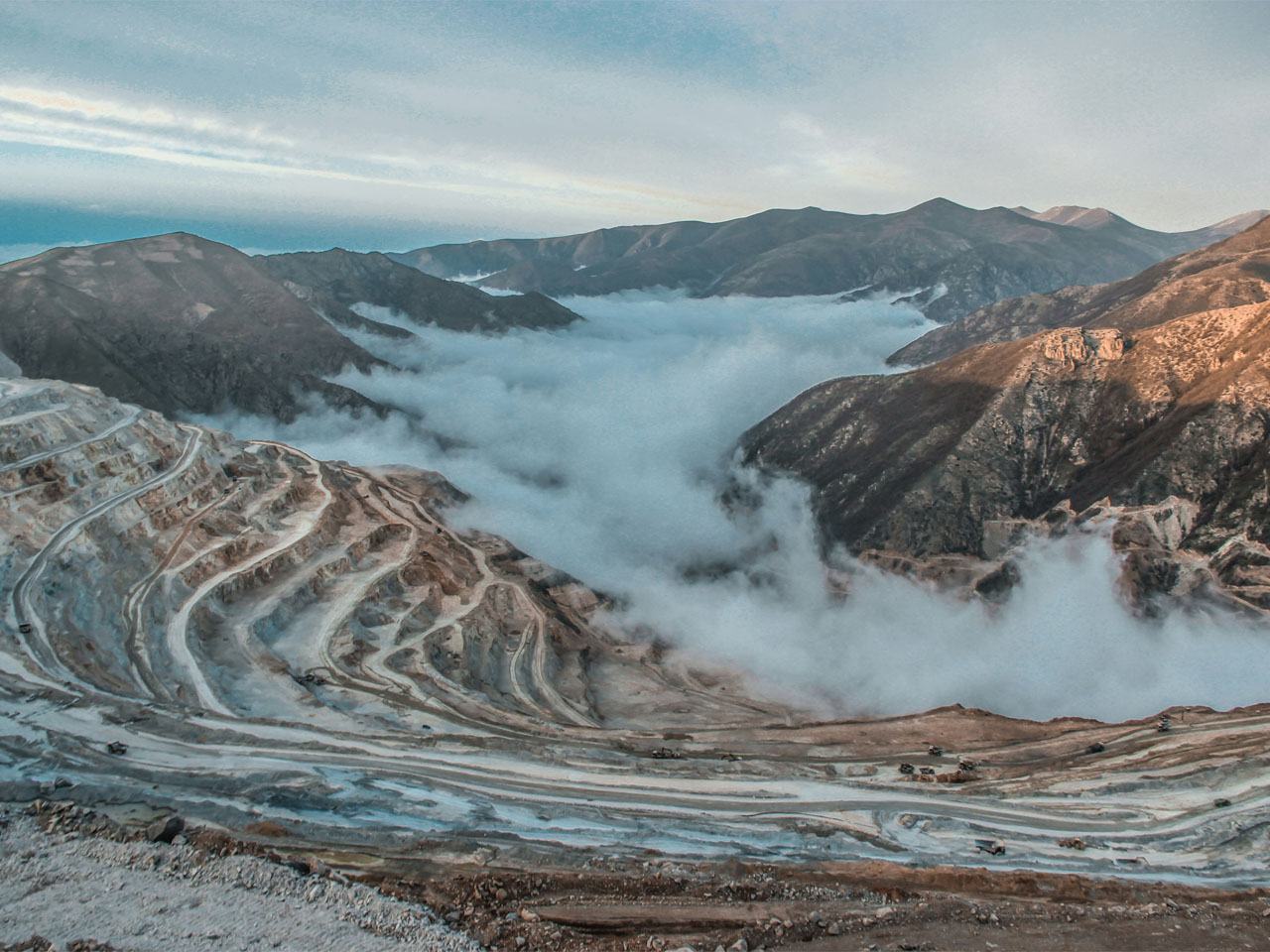 White blankets of snow on the mountains, while clouds gently drift overhead, shrouding the landscape.