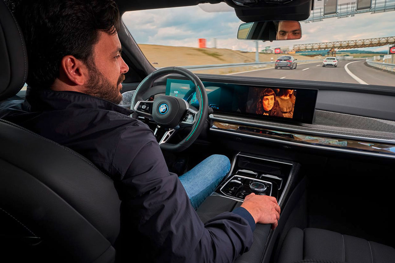 A man is watching a movie on the In-Car display while driving