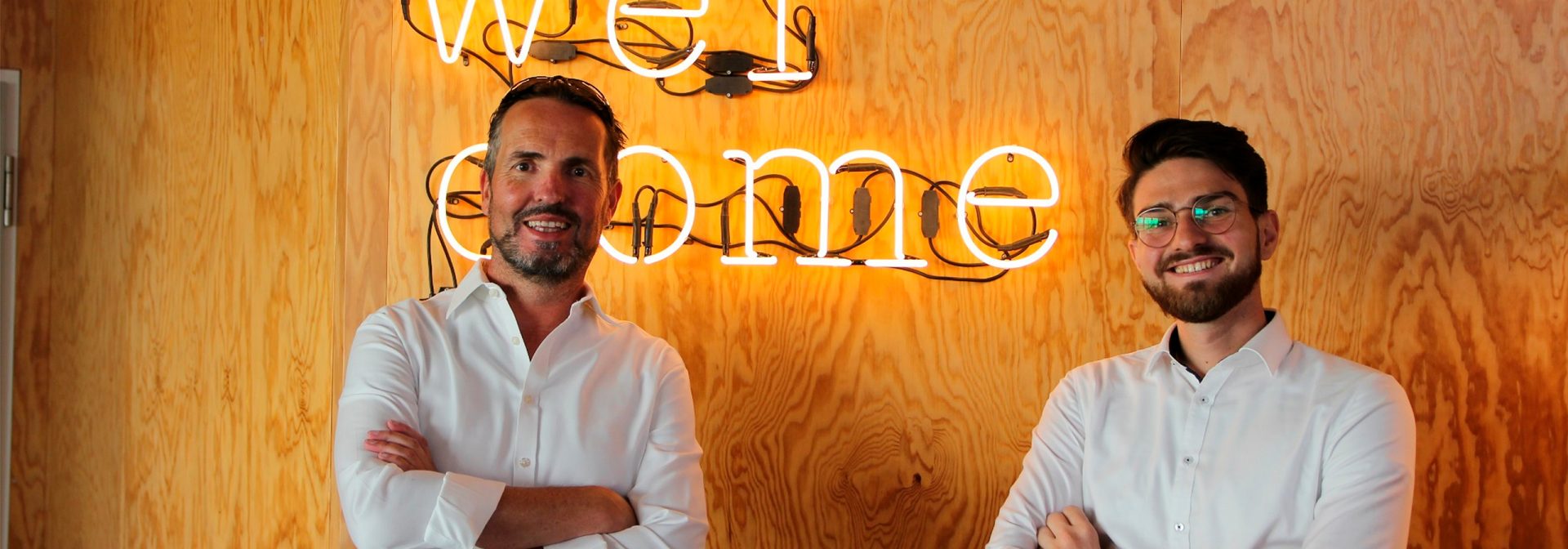 Two men smiling at the camera.